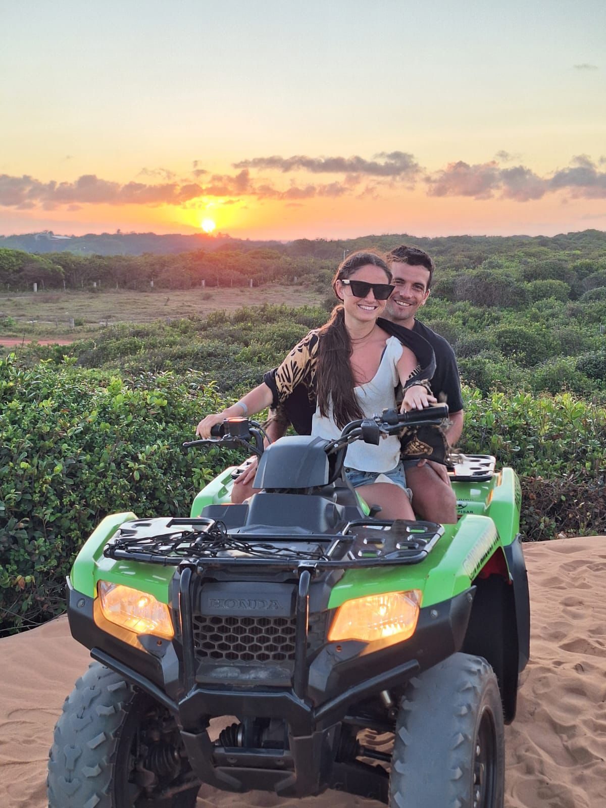 Pareja en cuatriciclo al atardecer en Pipa