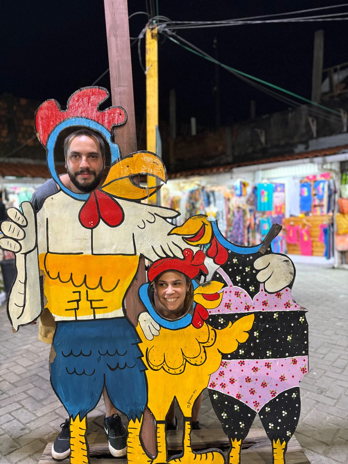 Pareja posando detrás de figuras de gallinas en Porto de Galinhas